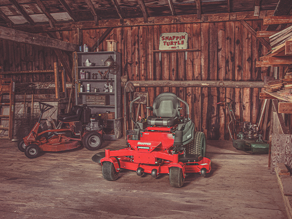 New Snapper mower in a garage next to an older model