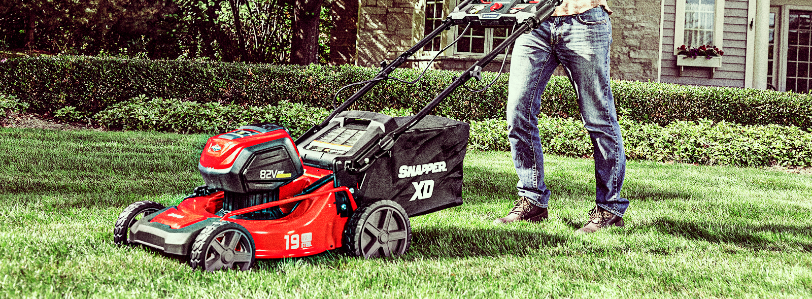 Person pushing an electric lawn mower