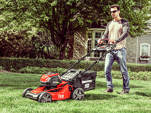 Person pushing an electric lawn mower