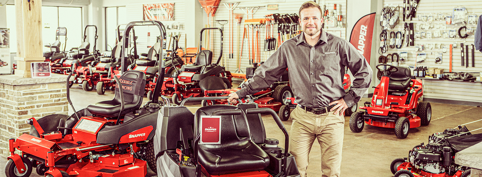 Dealer leaning against a Snapper zero turn mower