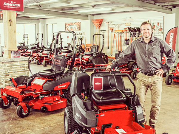 Snapper dealer leaning against a mower